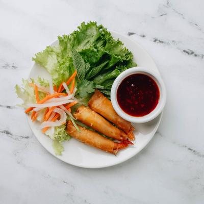 Fried shrimp rolls with lettuce, pickled vegetables, and red dipping sauce.