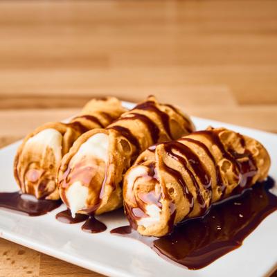 Cannoli topped with a rich chocolate syrup drizzle.