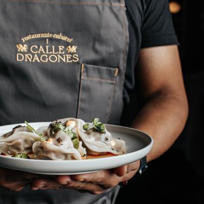 Chef holding a plate of “Crispy Gyosa”.