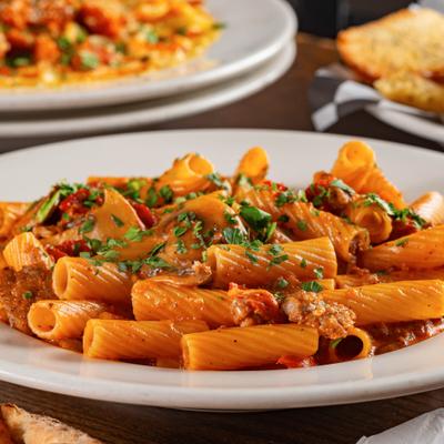 Rigatoni pasta with creamy meat sauce mushrooms, tomatoes, and sausage.