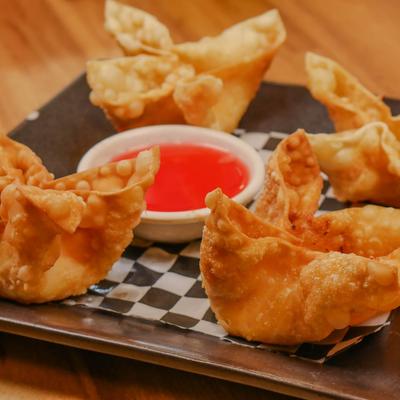 Crab Rangoon served with a dipping sauce.