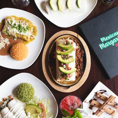 A spread of Mexican dishes and drinks including a burritos, enchiladas, churros, and margaritas.