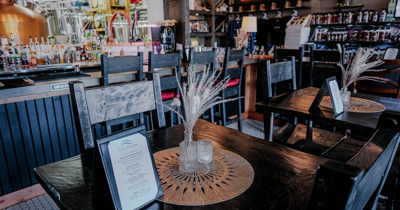 Interior, tables and chairs with bar in the back