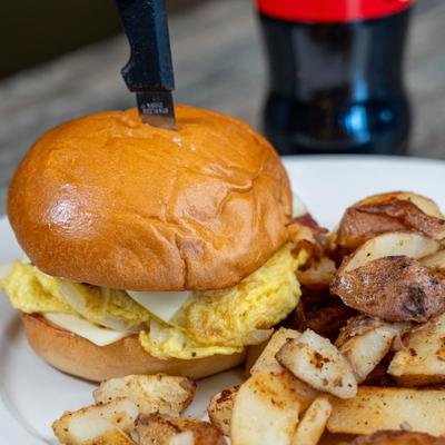 Bacon Egg & Cheese Sandwich served with a side of home fries.