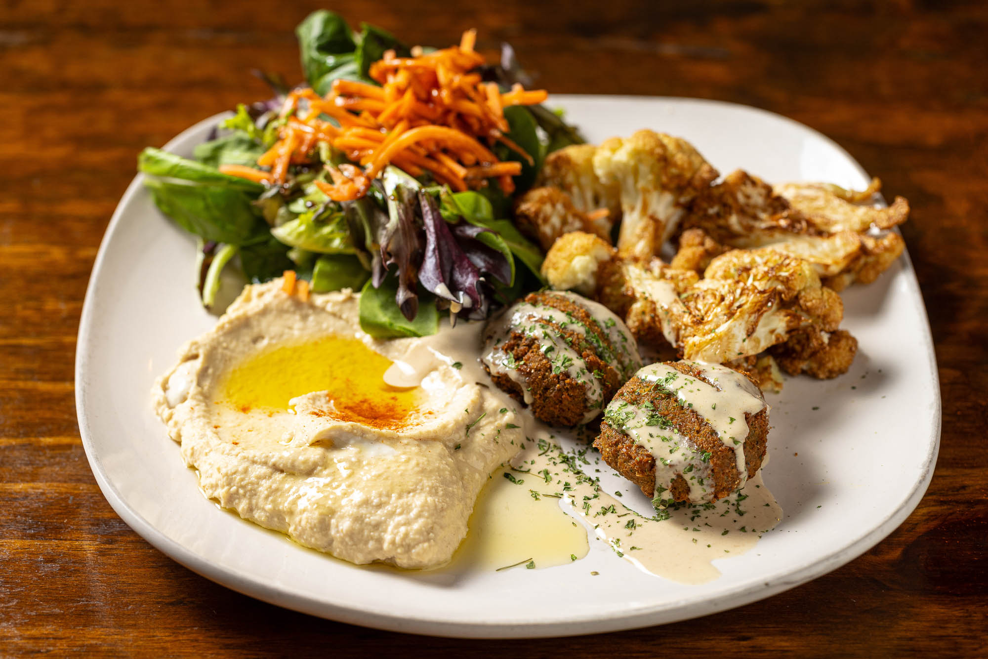 Sampler plate with Hummus, falafel, seasoned cauliflower, and house salad