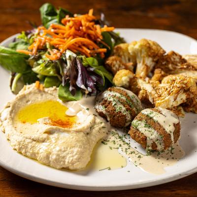 Sampler plate with Hummus, falafel, seasoned cauliflower, and house salad.