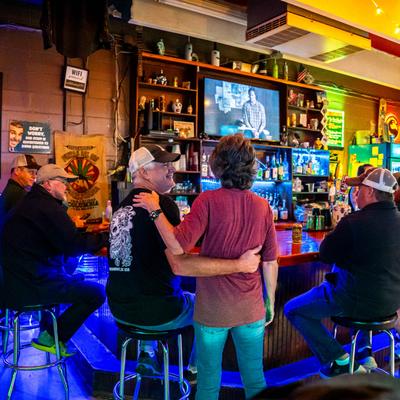 People at the bar hugging.
