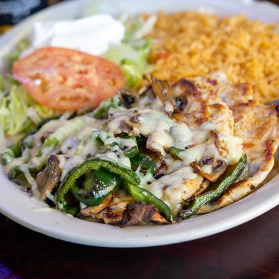 Grilled chicken, with mushrooms, cheese, peppers, salad, rice, and sour cream.
