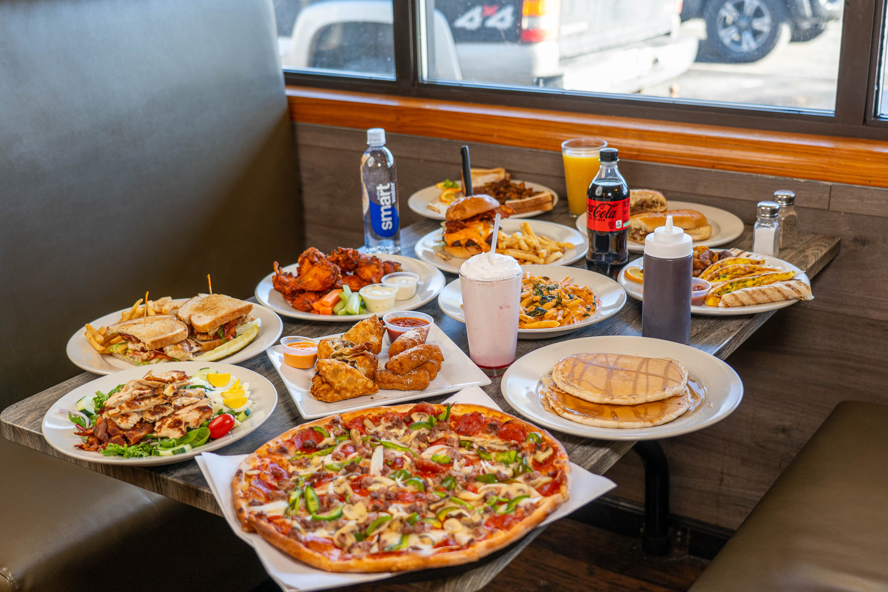 A large variety of food and drinks on a wooden table