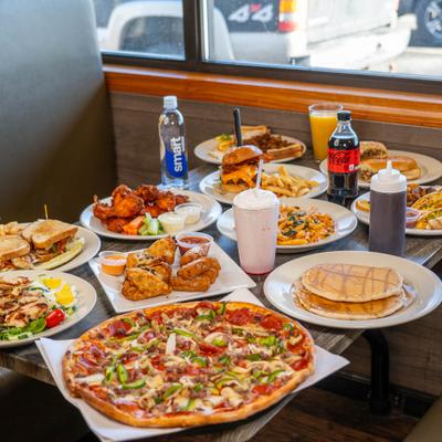 A large variety of food and drinks on a wooden table.