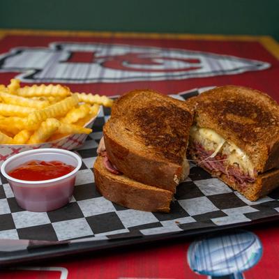 Grilled Reuben sandwich, with fries and ketchup.