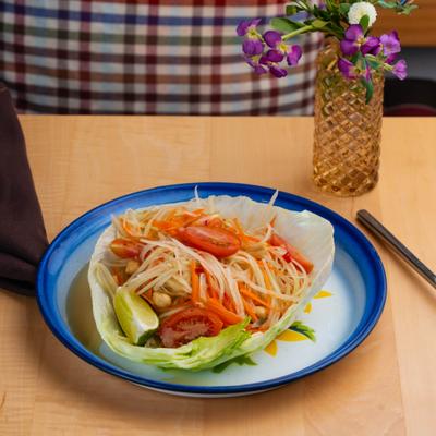 Thai Papaya Salad with cherry tomatoes, carrots, chilies, garlic and peanuts.