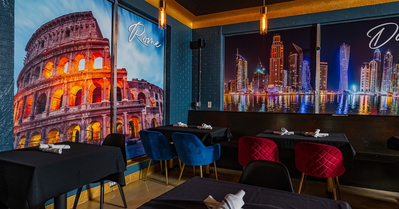 Interior, seating area, tables with black tablecloths and upholstered chairs in different colors