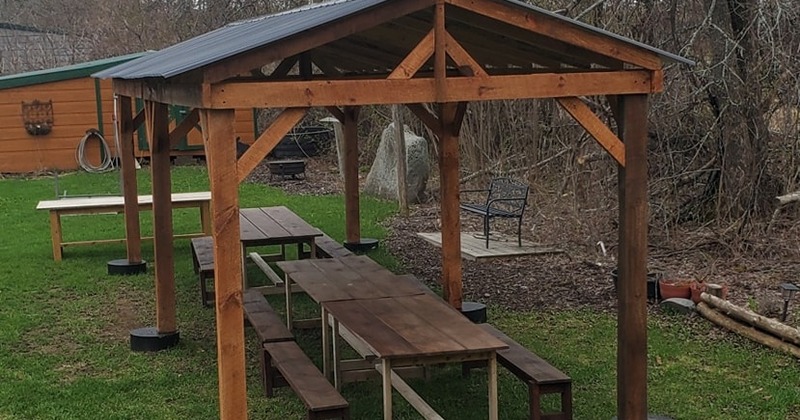 A serene wooden gazebo with benches and tables