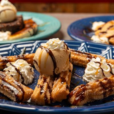 Churros with whipped cream, ice cream, caramel and chocolate drizzle.