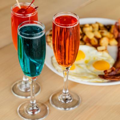 A mimosa flight paired with a breakfast plate.