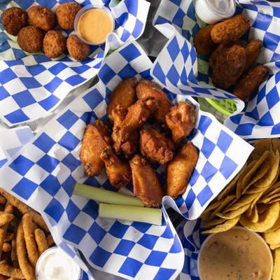 Top view of assorted fried appetizers on checkered paper.