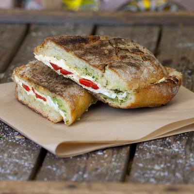 Pannini sandwich featuring fresh mozzarella, pesto and roasted red peppers.