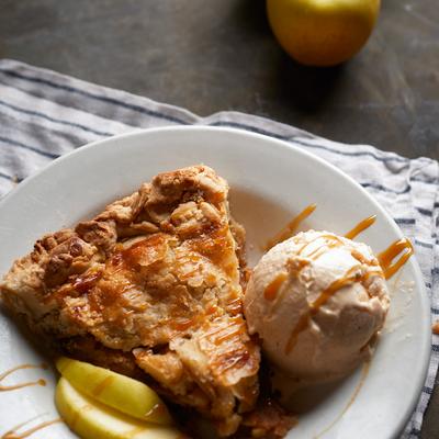 Pie slice served with ice cream and apple wedges.