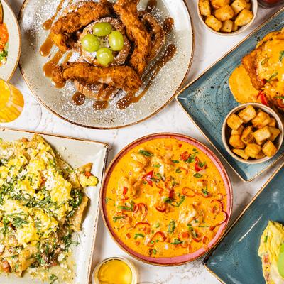 Overhead view of a table spread with various dishes and drinks.