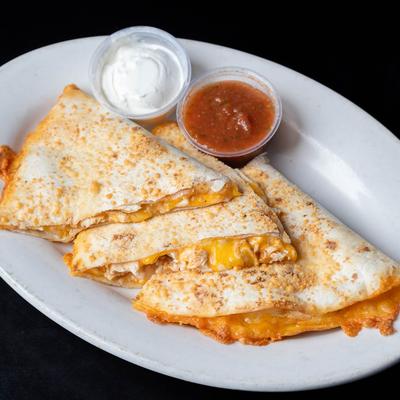 Chicken quesadilla with red salsa and sour cream.