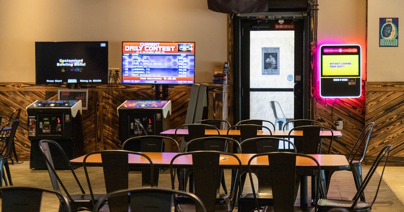 Interior, tables and chairs in seating area with gaming machines behind