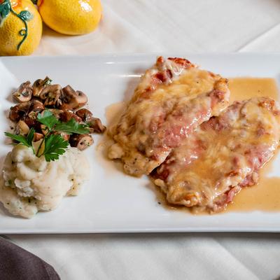 Chicken breast smothered in sauce, with mashed potatoes and mushrooms