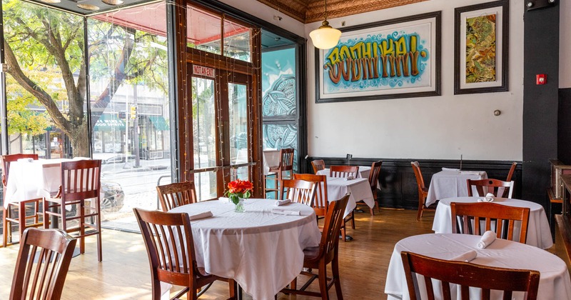 Interior, dining tables with white table cloths, wall art