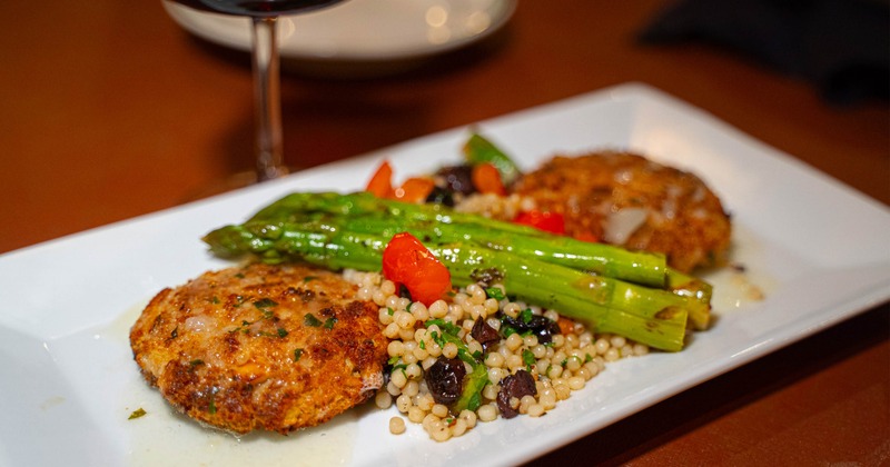 Baked crab cakes served with Mediterranean couscous and asparagus