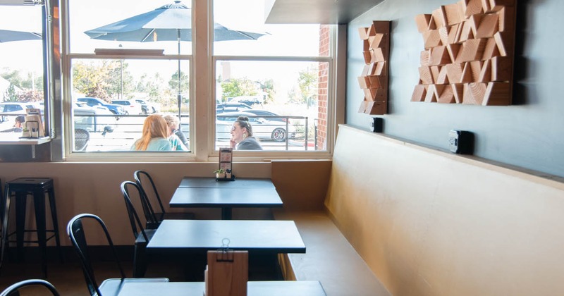 Interior, tables, chairs and a long, high back bench