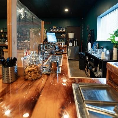 Bar area featuring a wooden counter, coffee station, paper cups, and cookie jars.