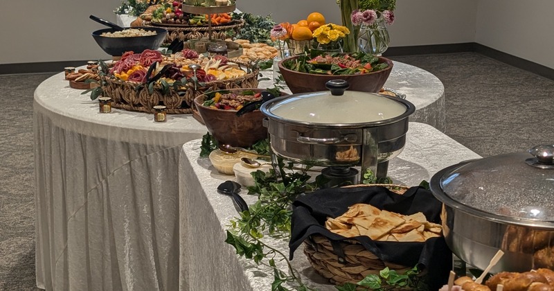 A greenery decorated buffet table displaying an array of food items