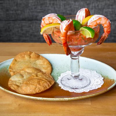 Colossal shrimp cocktail served with two fried tortillas on the side.