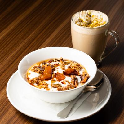 Yogurt Parfait served on the table alongside a cup of latte.