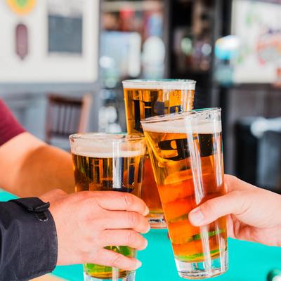 Interior, a group of people toasting with beers by a pool table.