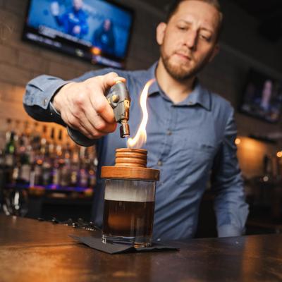 Bartender torching a cocktail.