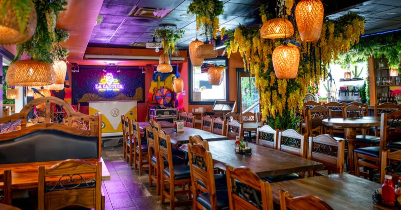 Colorful restaurant interior with wooden tables, woven pendant lights, hanging greenery