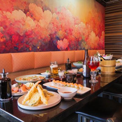 Tables laden with Japanese food including tempura, sushi, and drinks.