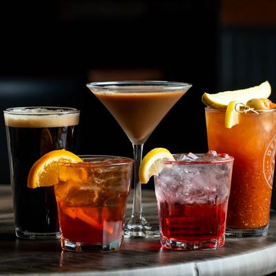 Assortment of cocktails and a glass of stout beer.