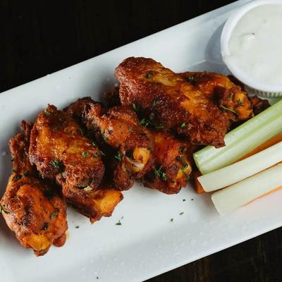 Chicken wings topped with herbs, served with celery and ranch dip.