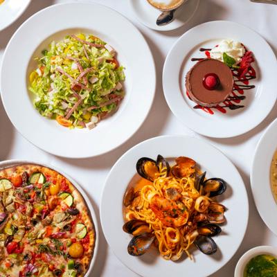 Overhead view of assorted dishes including pasta, pizza, salad, and chocolate dessert.
