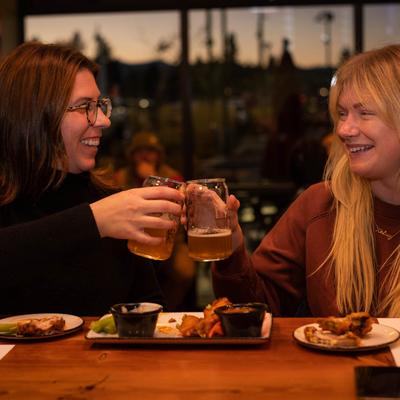 Two persons making a toast with their drinks.