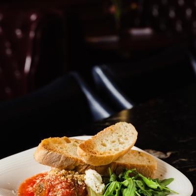 Meatballs, smothered in tomato sauce. parmesan, served with ricotta, and grilled bread
