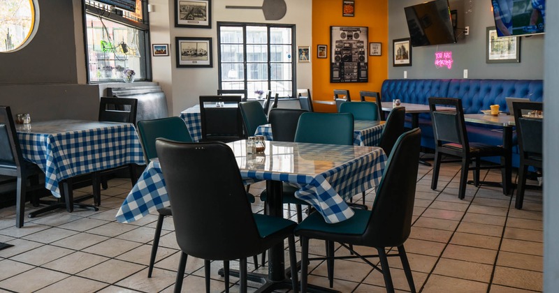 Inside, dining area, tables, black chairs, and wall-mounted TVs