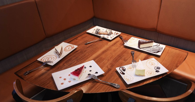 Plates with different cheesecake variants served on a table