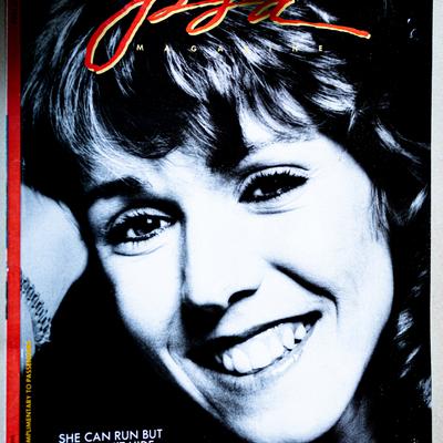 A partial view of a magazine cover featuring a person smiling