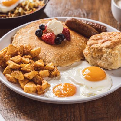 Pancakes and fried eggs, with side of home fires, sausage and biscuit