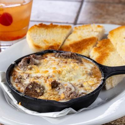 Tips, Bleu dish served  served in a mini cast-iron skillet with garlic toast.