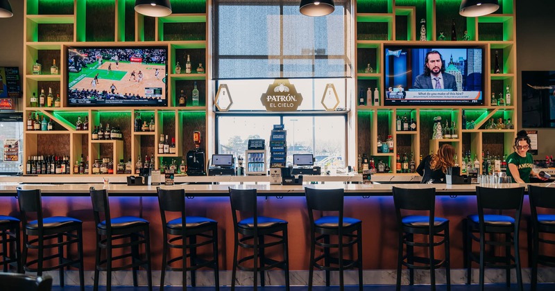 Interior, bar area, bar with stools, over-the-wall liquor shelves, large TVs