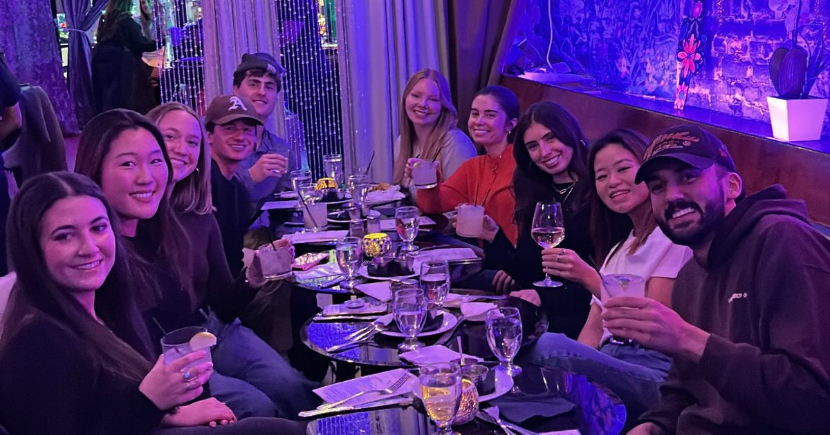 Friends sharing drinks around a long dining table